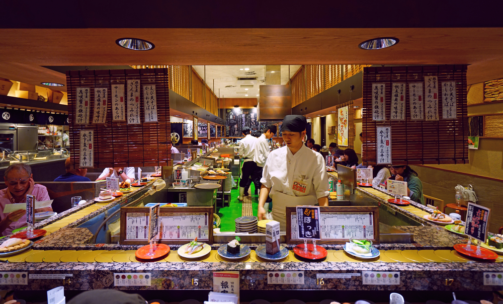 SAPPORO, JAPAN -26 JUN 2017- Inside view of a kaitenzushi conveyor belt sushi restaurant in Sapporo. Consumers pile up colored empty plates when they are finished eating.