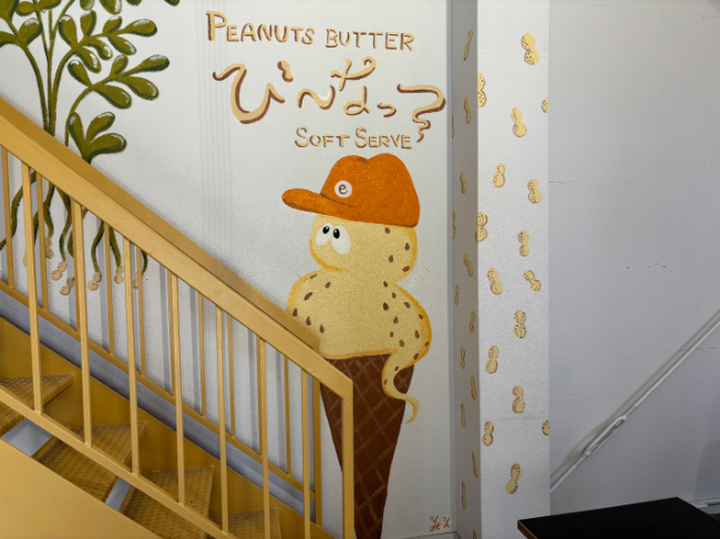 店内奥の壁に描かれたピーナッツソフトクリームモチーフのキャラクターとアート