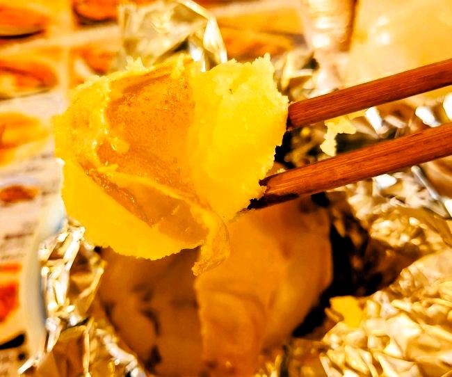 焼きたてのじゃがバターを箸でつまむ